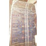 An Eastern hand-knotted wool carpet with geometric decoration on red and blue ground,