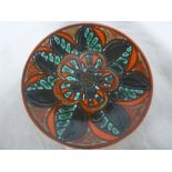 A Poole pottery Delphis circular charger with floral decoration on red ground