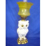 A German china oil lamp in the form of an owl on a rocky base,