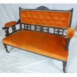 A small late Victorian carved settee upholstered in buttoned fabric on turned supports with castors