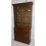 A 19th Century mahogany bookcase with cupboard enclosed by two panelled doors,