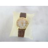 A gentleman's slim wristwatch by Garrard in gold plated case with leather strap