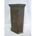 A small 19th Century inlaid pine and oak hanging corner cupboard with shelves enclosed by a central