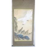 A Japanese painted rectangular scroll depicting an eagle within a landscape within fabric mounts