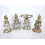 Four various oil lamps in the form of owls with floral decorated bases and brass mounts