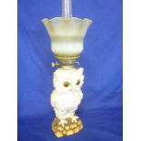 An unusual German china oil lamp in the form of an owl standing on a rocky outcrop with brass