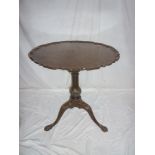 A Georgian style mahogany circular tilt-top occasional table with pie-crust edge on carved tripod