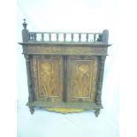 A late 19th/early 20th Century poker-work table cabinet with shelves enclosed by two floral