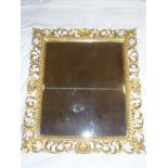 A rectangular wall mirror in ornate gilt scroll decorated frame 31" x 27"