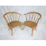 A pair of 1960's Ercol "cow-horn" pattern easy chairs with spindle backs and shaped seats on
