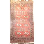 A 20th Century Eastern wool rug with geometric decoration on red and blue ground 67" x 36"