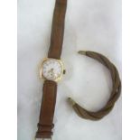 A 9ct gold gentleman's wristwatch with circular enamelled dial and leather strap