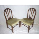 A set of four late 19th Century carved mahogany dining chairs with arched and rail backs,