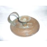 A Newlyn copper circular chamber candlestick by H Dyer decorated in relief with raised fish,