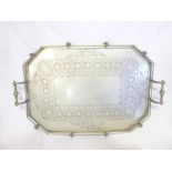 A large old electroplated rectangular two handled tea tray with engraved decoration and rail