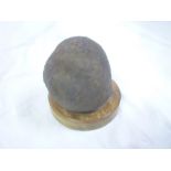 A Napoleonic 32lb iron cannon ball with wooden stand