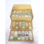 A box containing a selection of Victorian and later microscope slides and specimens,