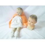 An old doll with painted composition head and cloth body and one other composition doll's head and