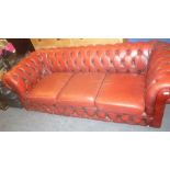 A three seat Chesterfield sofa upholstered in red buttoned leather (af)