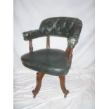 A late Victorian mahogany swivel office style chair upholstered in buttoned leather cloth with