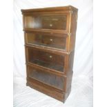 A Globe Wernicke mahogany four-tier stacking bookcase with glazed folding fronts and base drawer