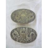 A pair of Chinese silver mounted oval clothes brushes decorated in relief with dragons