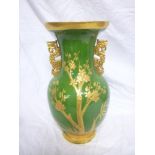 A late 19th century pottery tapered two-handled vase with floral decoration on gilt and green