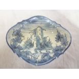 An unusual Delft oval bowl with blue and white painted landscape decoration on four scroll feet 11"
