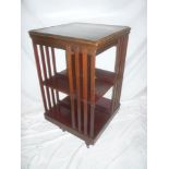 A late Victorian/ Edwardian mahogany square revolving bookcase on stand with casters