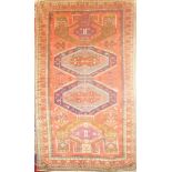 A good quality Eastern hand-knotted wool rug with geometric decoration on red ground,