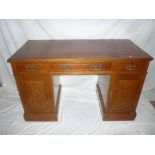 A Victorian walnut rectangular pedestal desk with three drawers in the frieze and cupboards