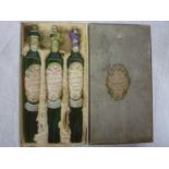 An unusual boxed set of three green tinted glass eau de cologne bottles "Favorita" by Collins of