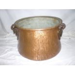 A large Middle Eastern-style copper circular cauldron/cooking pot with iron ring handles,