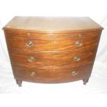 A George III mahogany bow front chest of three long drawers below a brushing slide on turned legs