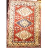 A good quality Eastern hand-knotted wool rug with geometric decoration on red and cream ground 64"