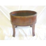 A good quality brass mounted walnut oval wine cooler on shaped legs