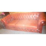 A three seat Chesterfield sofa upholstered in red buttoned leather (af)