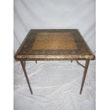 An unusual Eastern decorated card and metal folding square occasional table with floral decorated