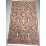 An Eastern hand-knotted wool rug with geometric decoration on red and blue ground 73" x 44"