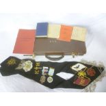 A case of various Masonic regalia including embroidered sash with eagle pendant,