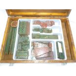 A wooden box containing a selection of 1920's/30's period dark green and dark red Meccano