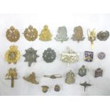 A selection of various original military cap badges and insignia including Bronze Middlesex