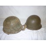 An original Second War American steel combat helmet with liner and one other similar steel helmet