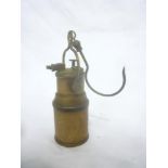 An old small brass miner's acetylene hanging lamp with cylindrical body and swivel crook