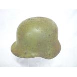 A Second War German steel helmet with original green painted finish and replacement liner