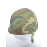A Second War/post War American steel combat helmet with liner and camouflaged cover