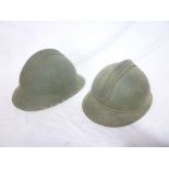 Two French First War painted steel combat helmets with raised combs (minus liners)