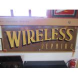 A large painted wooden sign 'Wireless Repairs'