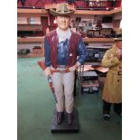 A figure of John Wayne stand with shotgun,