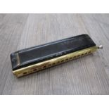 A Hohner Super 64x Chromonica in black and gold